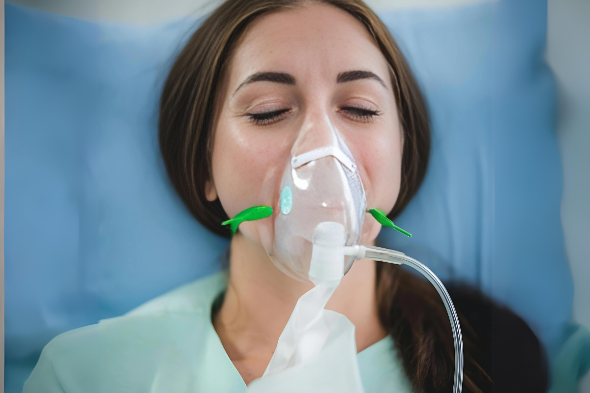 an unconscious woman wearing an oxygen mask